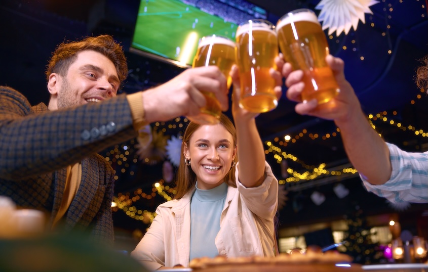 Friends toasting beers at a sports bar